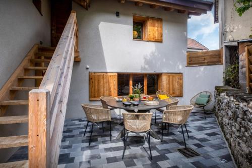 a patio with a table and chairs and stairs at Chalet 65bis - OVO Network in Thônes
