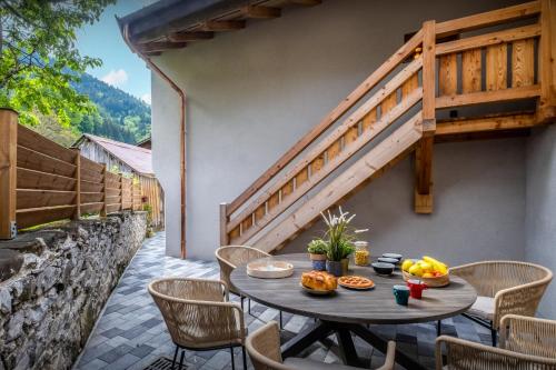 un patio con una mesa y sillas y una escalera en Chalet 65bis - OVO Network, en Thônes