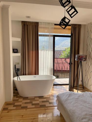 a large white bath tub in a room with a window at Sunny guesthouse in Kazbegi