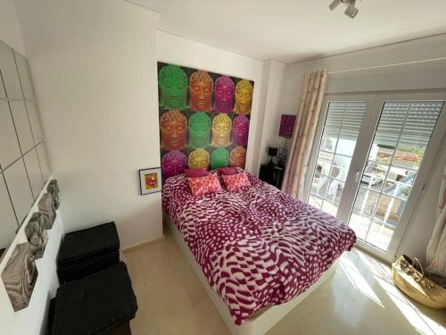 um quarto com uma cama com um edredão colorido em Apartamento Club Náutico con piscina em Denia