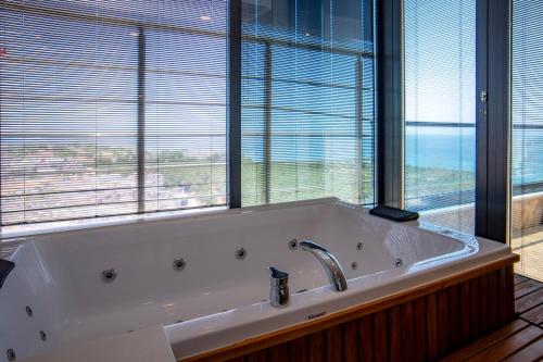 a large bath tub in a room with windows at CİTY POİNT BEACH&SPA HOTEL in Didim