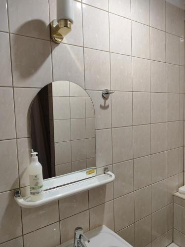 baño con espejo y lavabo en Pokój dwuosobowy z prywatną łazienką - Piotrkowska 262-264 pok 303 en Lodz