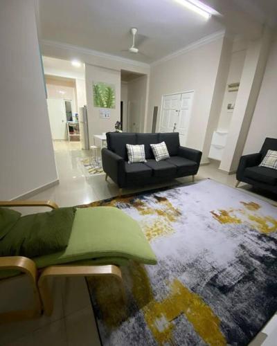 sala de estar con sofá y alfombra en FaZie Homestay Seri Nuang en Shah Alam