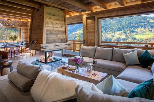 a living room with a couch and a fireplace at Chalet Beau Caillou - OVO Network in Saint-Gervais-les-Bains