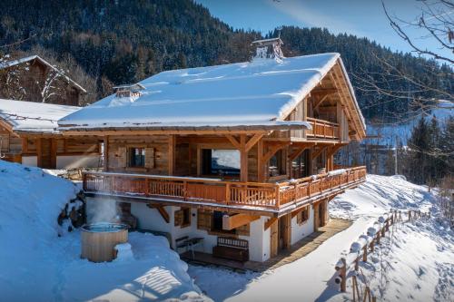 une cabane en rondins avec de la neige sur le toit dans l'établissement Chalet Beau Caillou - OVO Network, à Saint-Gervais-les-Bains