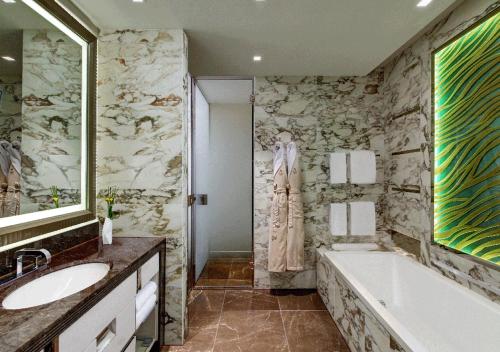 a bathroom with a bath tub and a sink and a bath tub at Waldorf Astoria Berlin in Berlin
