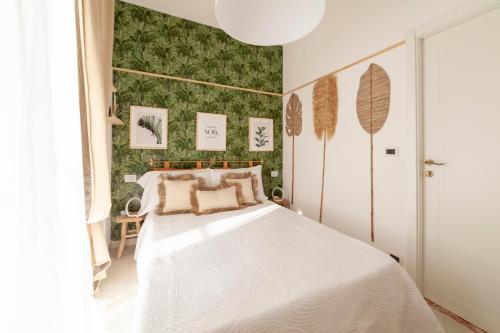 a bedroom with a white bed and a green wall at LA CASITA in Alassio