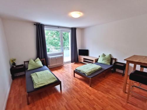 a living room with two beds and a table at Monteurzimmer Berlin Neukölln in Berlin