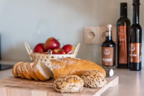 a table with bread and apples and bottles of wine at Apartamenty Augustynówka in Brzegi