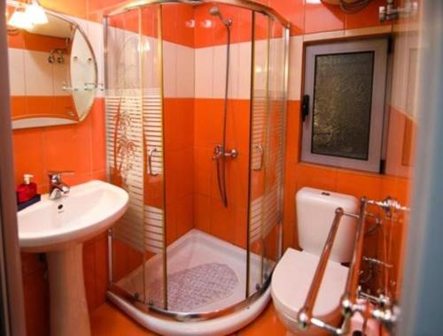 a bathroom with a shower and a toilet and a sink at Classic House Hotel in Korçë