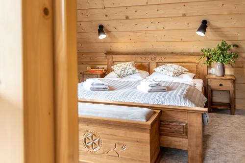 a bedroom with a bed and a wooden wall at Apartamenty Augustynówka in Brzegi