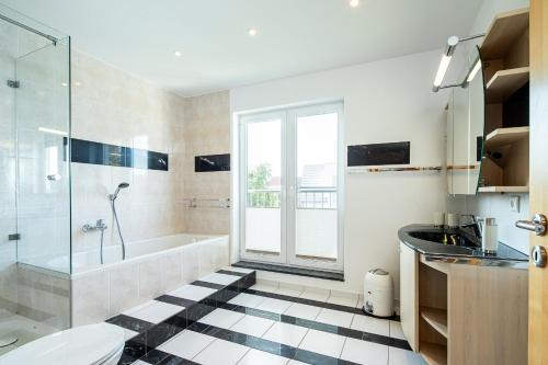 ein Badezimmer mit Badewanne, Dusche und Waschbecken in der Unterkunft Haus Annelie FEWO 3 EG/OG in Dranske