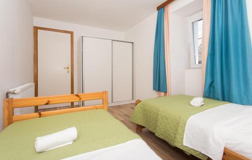 a bedroom with two beds and blue curtains at Villa Lucia in Vukići