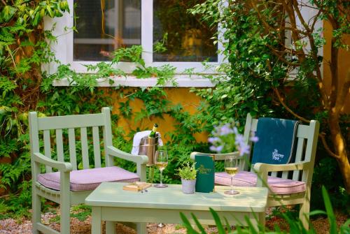 a table with two chairs and a table with wine glasses at The Killarney Park in Killarney