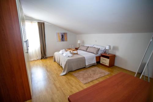 1 dormitorio con cama blanca y suelo de madera en Villa Musulin en Metković