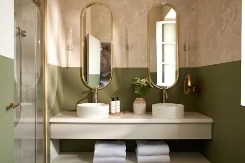 a bathroom with two sinks and two mirrors at Château Léognan, Domaine viticole - proche Bordeaux in Léognan