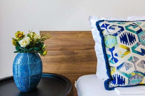 un vase bleu assis sur une table à côté d'un oreiller dans l'établissement Burgas Residence 402, à Bourgas