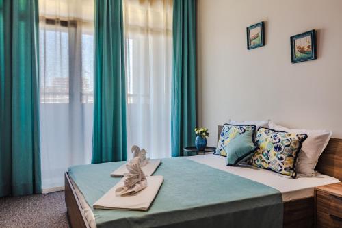 - une chambre avec un lit et des rideaux verts dans l'établissement Burgas Residence 402, à Bourgas