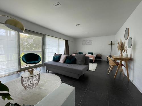 a living room with a gray couch and a room with a couch at Perfect getaway in Bruges! in Bruges