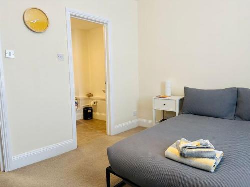 um quarto com uma cama com toalhas em Studio apartment, The Suffolks. em Cheltenham