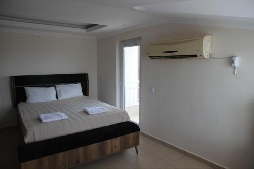 - une chambre avec un lit et un téléphone sur le mur dans l'établissement Villa, à Belek