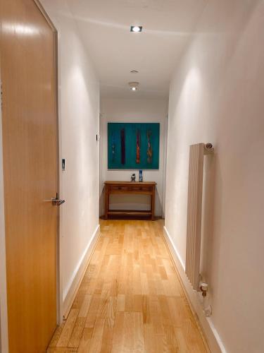 an empty hallway with a door and a wooden floor at Canary Wharf - Luxury Apartments in London