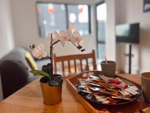 a wooden table with a vase with flowers on it at Canary Wharf - Luxury Apartments in London