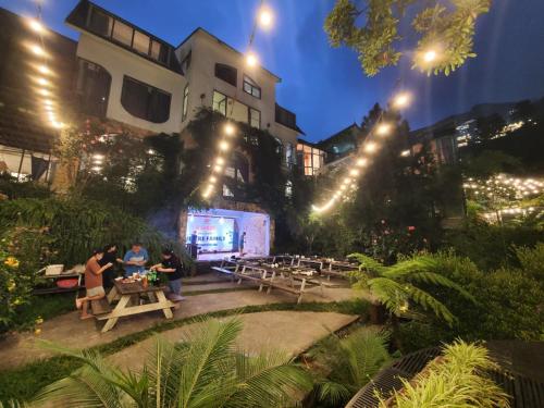 a group of people sitting at tables in a courtyard at night at Le vent Tam Đảo homestay in Tam Ðảo