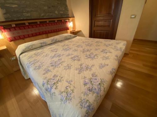 a bedroom with a bed with a floral bedspread at Chambres D'Hotes de Montagne in Pré-Saint-Didier