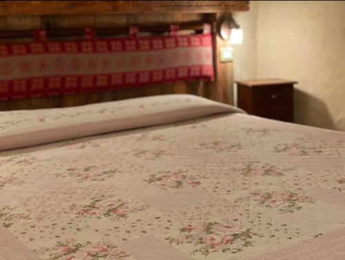 a bed with a pink bedspread with flowers on it at Chambres D'Hotes Maribel in Pré-Saint-Didier