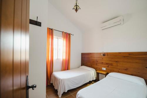 サオラにあるLas casitas de zahora - casitasmanoliのベッド2台と窓が備わる客室です。
