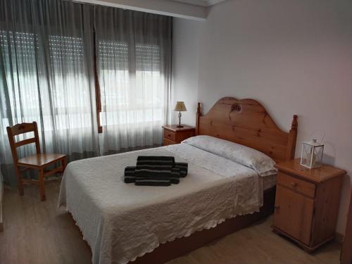 - une chambre avec un grand lit et une tête de lit en bois dans l'établissement Piso Turístico Bahía San Vicente, à San Vicente de la Barquera