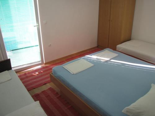 Habitación pequeña con 2 camas y ventana en Apartments Primorac Podaca, en Podaca