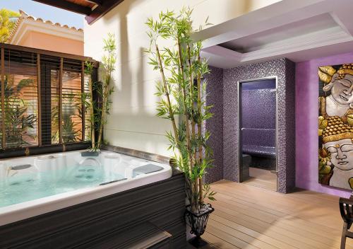 baño con una gran bañera con plantas. en Green Garden Eco Resort & Villas, en Playa de las Américas