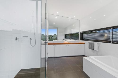 een witte badkamer met douche en wastafel bij Saltwater in Blairgowrie