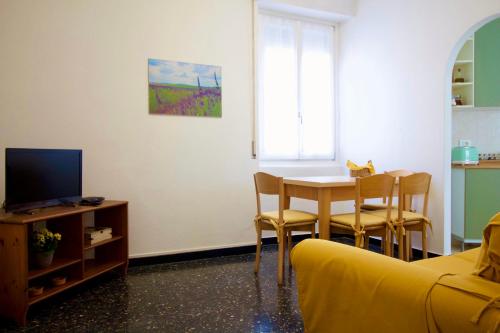 a living room with a table and a yellow couch at La casa dei nonni in Moneglia