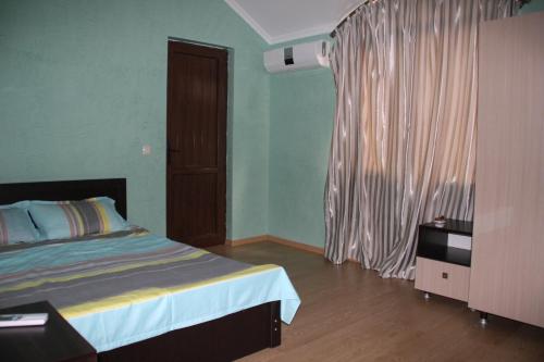 a bedroom with a bed and a window with curtains at Guest House Kobuleti in K'obulet'i