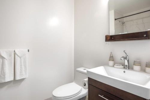 a white bathroom with a toilet and a sink at Hayes Valley Studio w Rooftop WD 1 min to BART SFO-108 in San Francisco