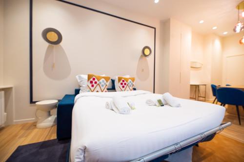 a bedroom with a large white bed in a room at Loft in canal saint martin in Paris