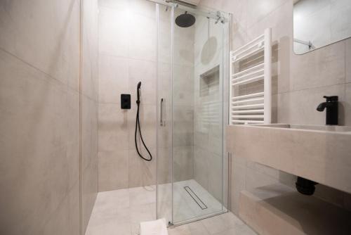 a shower with a glass door next to a sink at Loft in canal saint martin in Paris