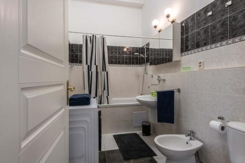 a white bathroom with a sink and a toilet at Centrally located 3BD home near National Museum in Prague