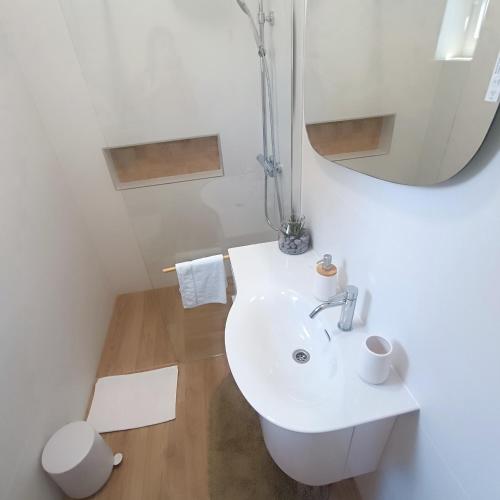 a white bathroom with a sink and a mirror at Villa Fragola 3 in Doli