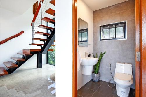 a bathroom with a toilet and a staircase at 2 Bays Villa in Thong Nai Pan Yai