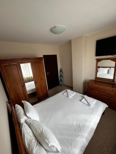 sypialnia z dużym białym łóżkiem i lustrem w obiekcie Bansko Royal Towers Private Apartment V&K w mieście Bansko