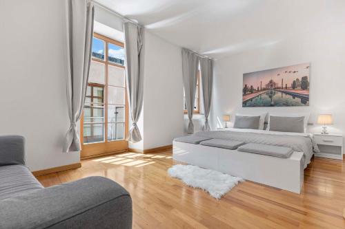 a white bedroom with two beds and a couch at Charming apartment in the heart of Bratislava in Bratislava
