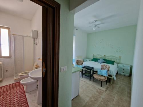 a bedroom with a bed and a bathroom with a sink at Baida Santos in Santa Maria la Palma