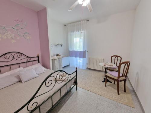 a bedroom with a bed and a chair and a table at Baida Santos in Santa Maria la Palma