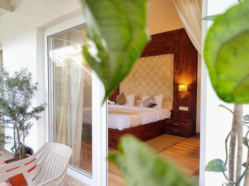 a bedroom with a bed and a large window at Delightz Inn in Ooty