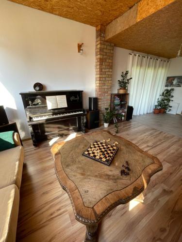 a living room with a table and a piano at Dom Coacha i Mentora in Wysowa-Zdrój
