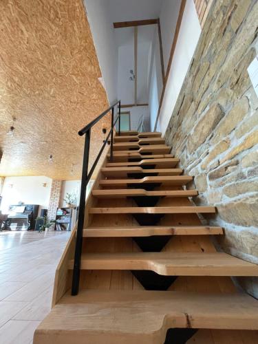una escalera en una casa con una pared de piedra en Dom Coacha i Mentora en Wysowa-Zdrój